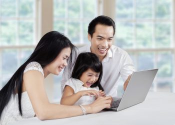 Three member of happy family using laptop computer for browsing internet